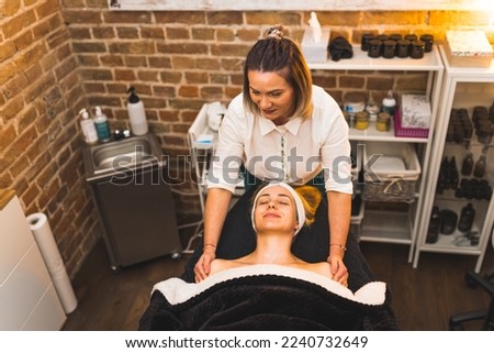 SPA day concept. Female massage therapist giving a shoulder and neck massage to her client on SPA bed. High angle shot. Indoor. Copy space. High quality photo