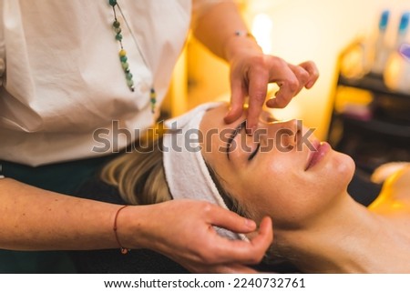 Young relaxed woman during face massage. SPA and relaxation concept. Indoor shot. Closeup shot. Copy space. High quality photo