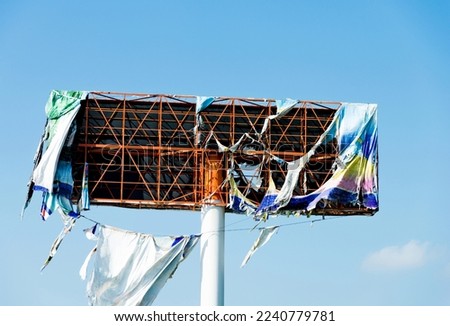Broken metal billboard in blue sky