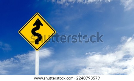 Yellow warn sign with switchback arrow starting from the right on blue sky background