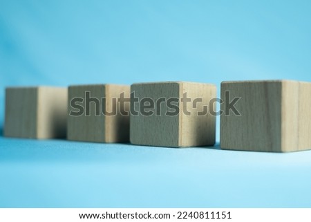 Focus on Blank wooden cubes in row over blue background.
