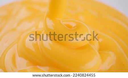 Pour yellow cheese sauce close up Royalty-Free Stock Photo #2240824455