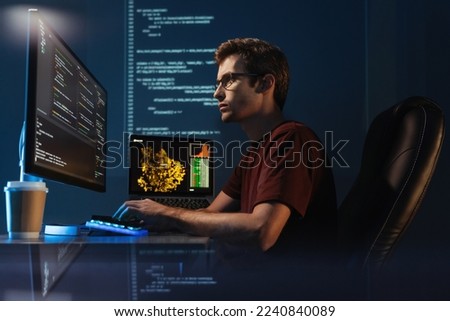 Software engineer working on new app, checking coding in bugging system, sitting in comfortable chair, typing in front of pc, on digital wall with code background Royalty-Free Stock Photo #2240840089