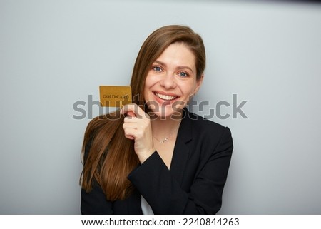 Smiling woman holding credit card wearing black business suit. Isolated female portrait.