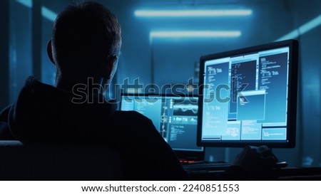 Computer Hacker in Hoodie. Obscured Dark Face. Concept of Hacker Attack, Virus Infected Software, Dark Web and Cyber Security. Royalty-Free Stock Photo #2240851553