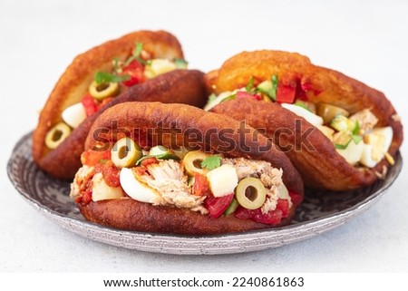 Fricasse is a savory donut  filled tuna, potato,boiled egg, olives and harissa.Traditional Tunisian food Royalty-Free Stock Photo #2240861863