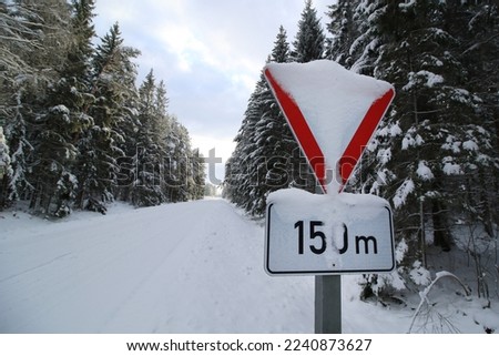 yield sign in the snowy forest