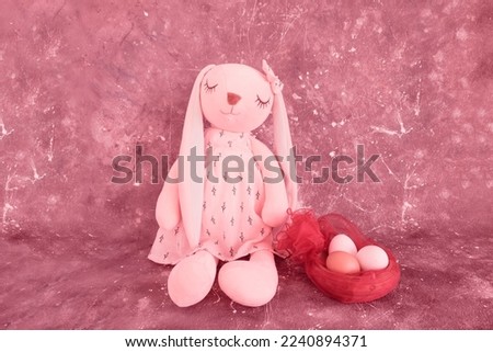 Beautiful Easter bunny and eggs in a basket on a dark background, Viva magenta color of the year. Greeting card concept. Red background.