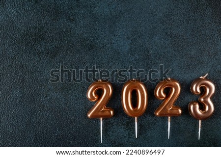Holiday background Happy New Year. Numbers 2023 made by gold candles