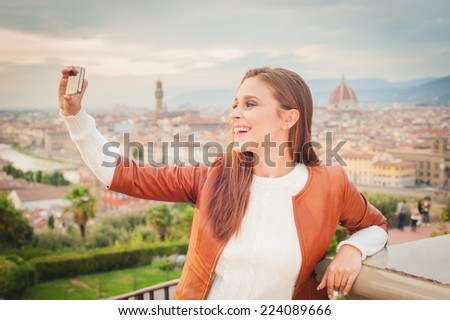 Beautiful young woman making a picture with background of Florence