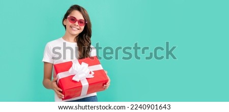 fashionable happy child in sunglasses hold gift box, shopping. Teenager girl with birthday gift, horizontal poster. Banner header with copy space.