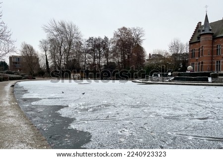 Frosted pond next to Brasserie Mariadal building in Zaventem, Belgium Royalty-Free Stock Photo #2240923323