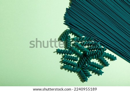 Spaghetti and Fusilli pasta with chlorella and spirulina extract, close-up. Pasta products with natural food dyes of organic origin. Design element, copy space.