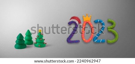 2023 numbers in colored cartoon style and Santa's hat and Christmas pines, all made by hand from plasticine. Happy New Year event poster, greeting card, 2023 calendar design