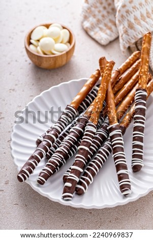 Chocolate covered pretzel rods homemade on a white plate with dark and white chocolate Royalty-Free Stock Photo #2240969837