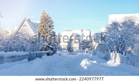 Winter fairy-tale landscape on the street with houses with a triangular roof and roads covered with a lot of snow Royalty-Free Stock Photo #2240977977