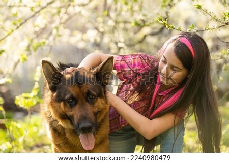 Little cute girl embracing and resting on shoulder dog.