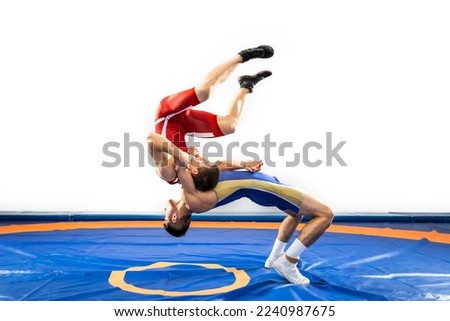 The concept of fair wrestling. Two greco-roman  wrestlers in red and blue uniform wrestling   on a wrestling carpet