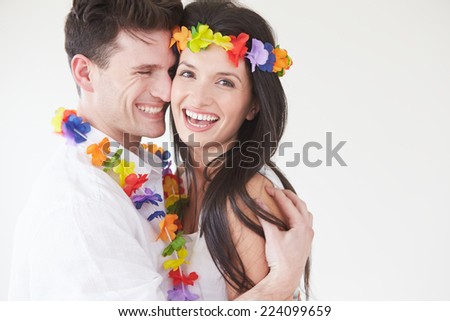 Couple Wearing Flower Garlands Against White Background
