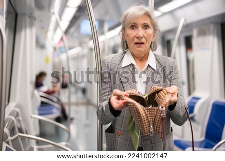 European lady can't find her belongings because they're was stolen from her handbag in subway train. Royalty-Free Stock Photo #2241002147