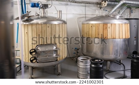 Beer tanks and barrels in brewery. Beer production equipment out of stainless steel.