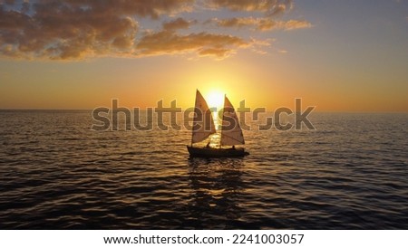 A sailboat moves through the setting sun at Gasparilla Island State Park on Boca Grande, FL.