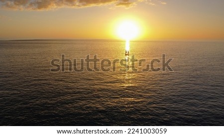 A sailboat moves through the setting sun at Gasparilla Island State Park on Boca Grande, FL.
