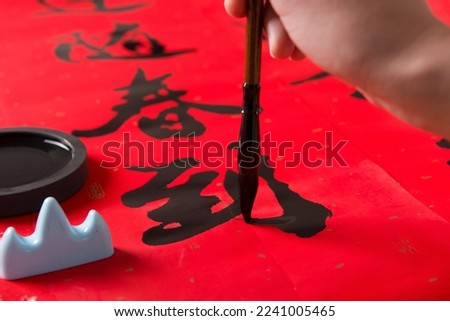 writing spring festival couplets to celebrate Chinese new year holidays .(the write word meaning fortune) Royalty-Free Stock Photo #2241005465