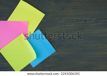 Empty color office paper for notice with curled corners on rustic board. Free copy space for text