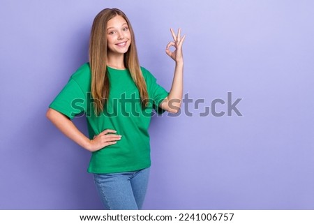 Photo of adorable cheerful cute lady wear green stylish clothes hand okey sign empty space isolated on purple color background