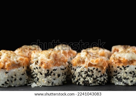 Sushi with scallop, sesame and cucumber on black background. Copy space