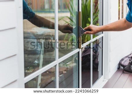 Worker use scraper cleaning window before installing tinting film. Royalty-Free Stock Photo #2241066259