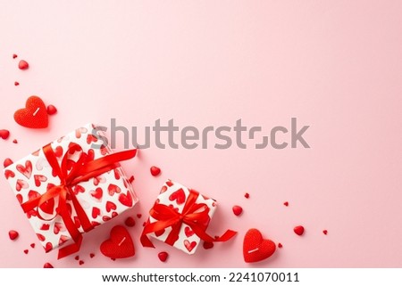 Saint Valentine's Day concept. Top view photo of gift boxes in wrapping paper with heart pattern candles and sprinkles on isolated pastel pink background with copyspace