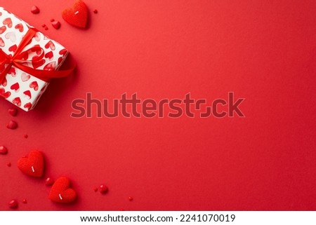 St Valentine's Day concept. Top view photo of present box heart shaped candles and sprinkles on isolated red background with copyspace