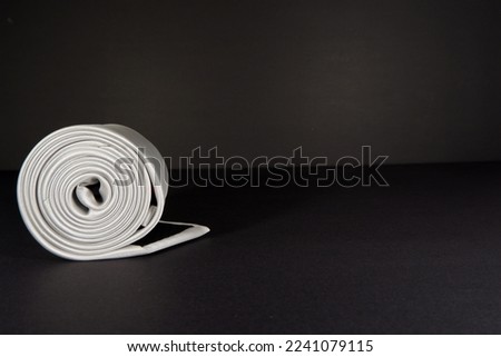 men's fashion polyester fabric necktie rolled isolated on black background single object concept photography  Royalty-Free Stock Photo #2241079115