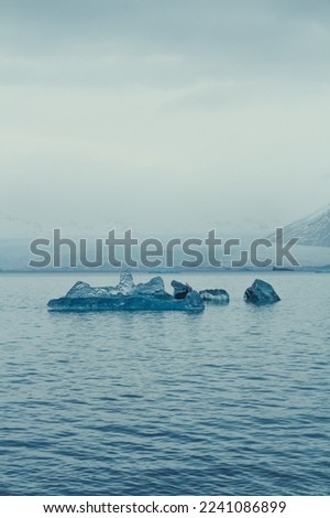 Spiky ice pieces in cold sea landscape photo. Beautiful nature scenery photography with grey sky on background. Idyllic scene. High quality picture for wallpaper, travel blog, magazine, article