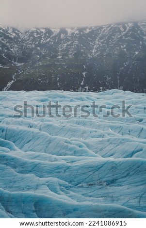 Blue glaciers in mountain bottom landscape photo. Beautiful nature scenery photography with sky on background. Idyllic scene. High quality picture for wallpaper, travel blog, magazine, article