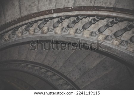 Winding stairs in old building interior photo. Beautiful urban architectural photography with semi dark hall on background. High quality picture for wallpaper, travel blog, magazine, article