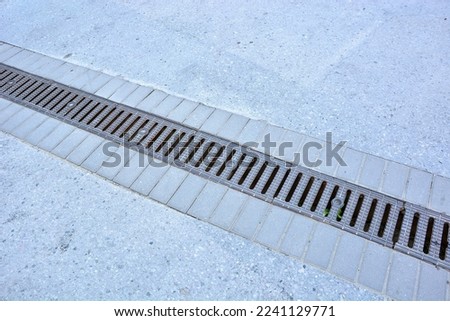 Linear drainage channel in the road Royalty-Free Stock Photo #2241129771