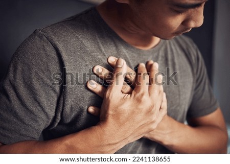 Take better care of your heart, it only beats for you. Shot of a young man experiencing chest pain at home. Royalty-Free Stock Photo #2241138655