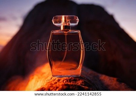 Perfumery industry and advertisement. Rounded glass golden perfume bottle on a rock background. Luxury perfume. The concept of the presentation of a fashion man fragrance. Royalty-Free Stock Photo #2241142855