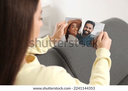 Woman ripping photo at home, closeup. Divorce concept