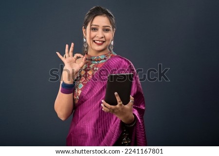 Beautiful young girl using mobile phone or smartphone on gray background
