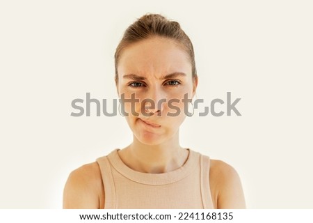 Angry frustrated female trying to keep calm curving and pursing her lips tightly, mad at her husband, frowning looking at camera. Negative human emotions, facial expression, body language
