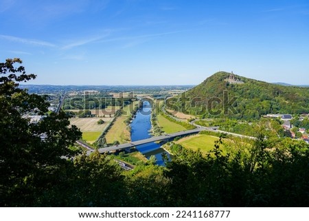 View of the landscape and the Weser from the Porta-Kanzel in Porta Westfalica. Green nature with a river, fields, hills and the Kaiser Wilhelm monument.	 Royalty-Free Stock Photo #2241168777