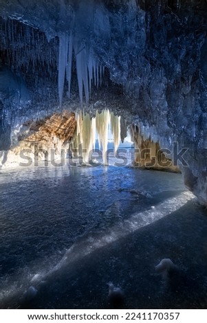 Icicles hang from the roof of an ice cave on Lake Superior during an extremely cold winter in Michigans Upper Peninsula. Ice curtains, created by a freeze-thaw cycle drape the entrance