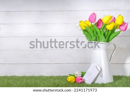 Mothers Day Greeting Card. Tulips Bouquet in Vase And Greeting Tag On White Wooden and Wooden plank background copy space