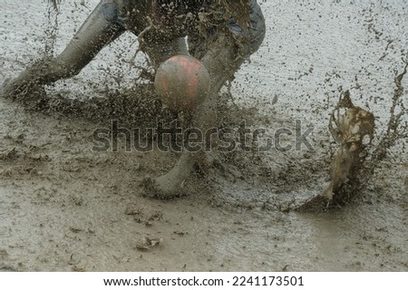 Playing football in the mud area 