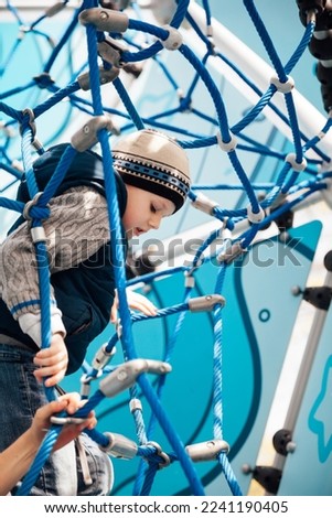 little boy playing on the playground in the park