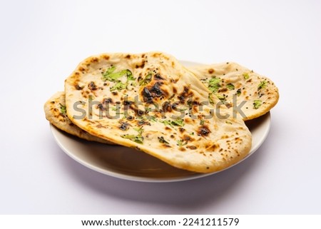 Tandoori naan, Indian Tandoori roti or flat bread served in a plate, isolated Royalty-Free Stock Photo #2241211579